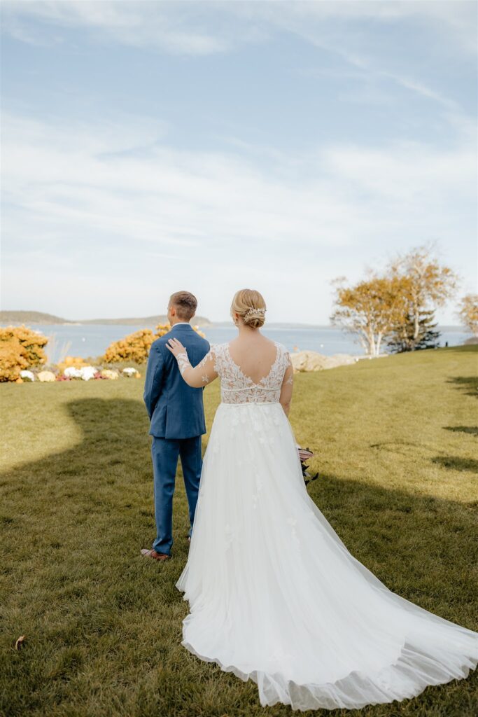 Bride is touching fiances shoulder to have him turn around for first look