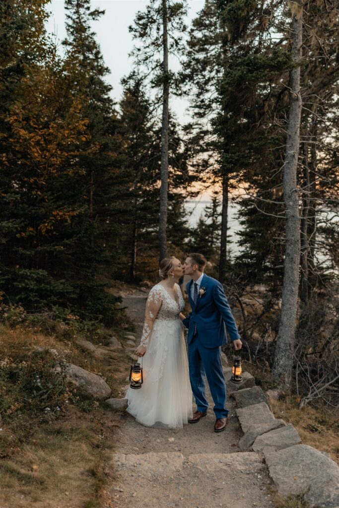 bride and groom photos posing with lanterns in the forrest of Maine