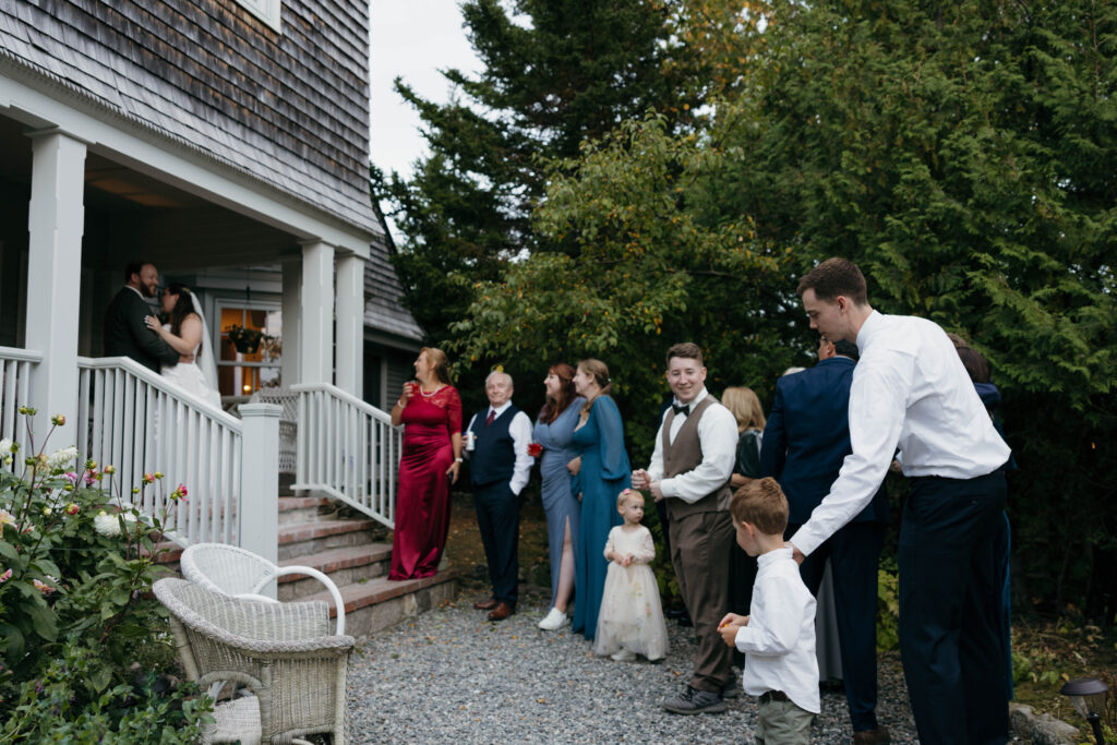 A family watching a couple's first dance outside of airbnb in Bar Harbor 